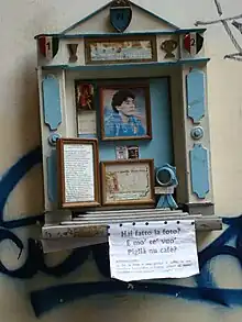 Photographie en couleurs. Autel en bois de couleur bleu ciel commune à l'Argentine et à Naples, accroché dans un mur des rues de Naples.