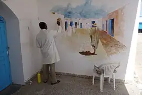 Artiste réalisant une fresque.