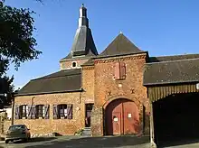 Clocher surgissant de l'entrée fortifiée du cimetière