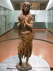 Statuette en bois d'une femme âgée faisant pénitence