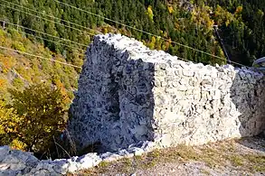 Murs formant un angle. Au milieu de celui de gauche se trouve une petite ouverture.