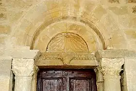 Le tympan rayonnantet le linteau orné d'une tête de bovidé.