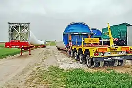 Segments du mât sur remorques et embase d'une pale.