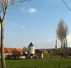 L'ancienne ferme fortifiée en pierre calcaire blanche et l'église.