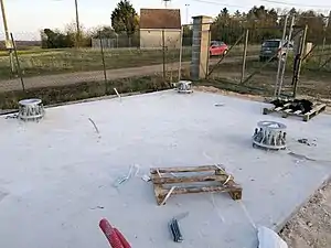 Plate-forme en béton avec les points d'ancrage du pylône.