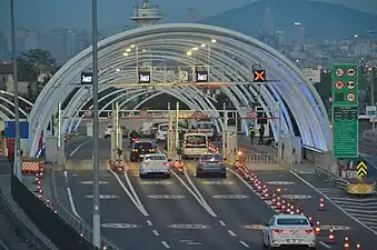 Photographie montrant une structure métallique semi-circulaire au-dessus d'une route.