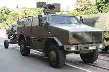 Un Dingo 2 de la Composante terre de l’armée belge avec une tourelle téléopérée tractant un obusier LG1 Mark II de calibre 105 mm le 21 juillet 2016.