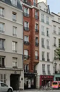 No 47 : immeuble très étroit en briques du 2e quart du 20e siècle.