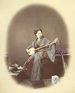 Photographie des années 1860 d'une joueuse de shamisen.