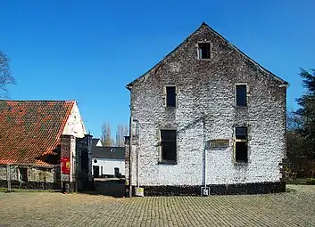 Le pignon du corps de logis et la grille d'accès.