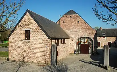 L'entrée de la ferme et la grange transformée en salle de spectacle.