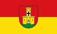 Blason en rouge et jaune avec un écu blanc orné d'une croix noire au milieu.