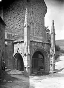 Photo en noir et blanc d'une fontaine recouvert d'un porche protégé par une grille.