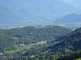 Vue des rochers de Comboire et de son fort depuis la tour sans Venin au nord-ouest ; en arrière-plan la plaine de Reymure, le Petit Brion et le pied du massif du Taillefer.