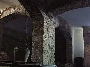 Le souterrain avec le pilier central soutenant l'infrastructure supérieure grâce aux quatre voussoirs plein cintre en briques.