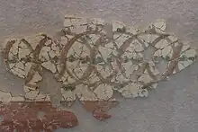 Photographie d'une fresque antique à motifs de cercles entrelacés.