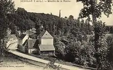 Carte postale sépia représentant un bâtiment au bord d'un cours d'eau caché par des arbres.