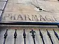 Indication murale « pharmacie » (à l'entrée de l'apothicairerie, fermée en 1942).