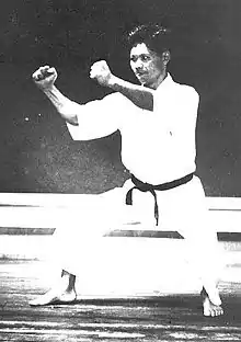Gigo Funakoshi en position kōkutsu-dachi, effectuant la défense chūdan-kakiwake-uke. En style Shōtōkan, on retrouve cette position dans le kata Heian Yodan.