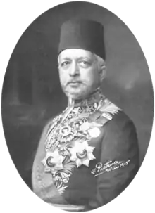 Portrait d'un homme barbu portant un fez et un costume diplomatique.