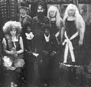 Photographie d'une troupe de cirque dont une femme aux cheveux crépus et deux autres albinos.