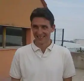 Portrait d'un homme qui porte un polo blanc.