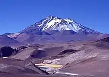 Un volcan enneigé dans un paysage de montagne désertique