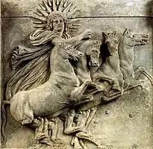 Bas-relief montrant Hélios, dieu du soleil dans la mythologie gréco-romaine, conduisant son char à quatre chevaux, un soleil rayonnant encadrant sa tête.