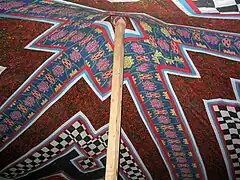 Mât central dans une tente décorée en patchwork.