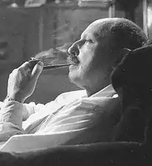 Photo noir et blanc d'un homme de profil, dégarni, fumant la pipe