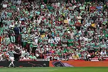 une footballeur tire un corner devant une tribune