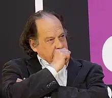 Photo d'un homme avec le poing fermé devant la bouche.