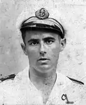 Officier de marine en tenue blanche, la casquette de travers, avec les deux galons d'enseigne de vaisseau de première classe