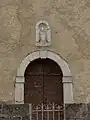 Le portail surmonté de la statue de saint Claude insérée dans une niche.