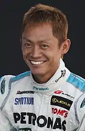 Photographie d'un pilote automobile japonais dans sa combinaison de course.