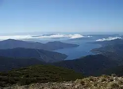 Photographie couleur d'un bras de mer observé depuis le sommet d'une montagne.