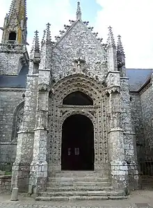 Extérieur du porche, vu de face. Le portail est richement sculpté, et encadré de contreforts à pinacles.