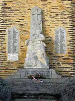 Monument aux morts, composé d'une stèle dressée où est sculpté un soldat mourant au pied de la Croix, encadrée par deux plaques de marbres portant les noms des défunts.