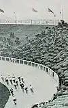Photo d'un peloton de coureur cyclistes abordant le virage d'une courbe dans un vélodrome.