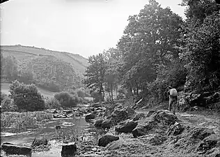 Homme portant un sac sur son dos sur un chemin longeant l'Inam.