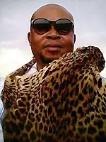 Photographie d'un homme noir portant des lunettes de soleil.