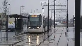tramway à la station Grand Hameau, sous la pluie.