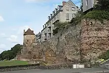 Vue d'une portion de mur dégagée et comprenant plusieurs tours dont deux sont en bon état et d'autres en ruines