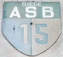 Blason de l'AS Bram XV (1906-2016) visible sur la façade de l'ancien « café Bénazet ».