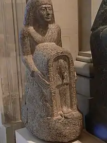 homme agenouillé devant une statue