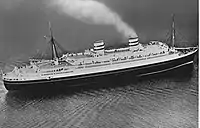 Photographie en noir et blanc vue du ciel, représentant un paquebot en pleine mer.