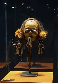 Tête trophée, Mundurucú. Os, cheveux, dents, cire, plumes, fibres. H. 43 cm. v. 1880. Brésil.
