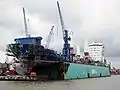 Cargo marchand en réparations dans un dock flottant.