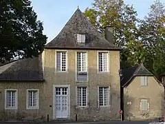 Photo d'une maison aux portes et fenêtres blanches et au toit en ardoise.
