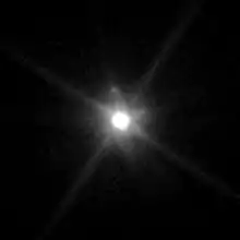 Un gros point blanc lumineux entouré d'une sorte d'aura ; un petit point gris est visible.